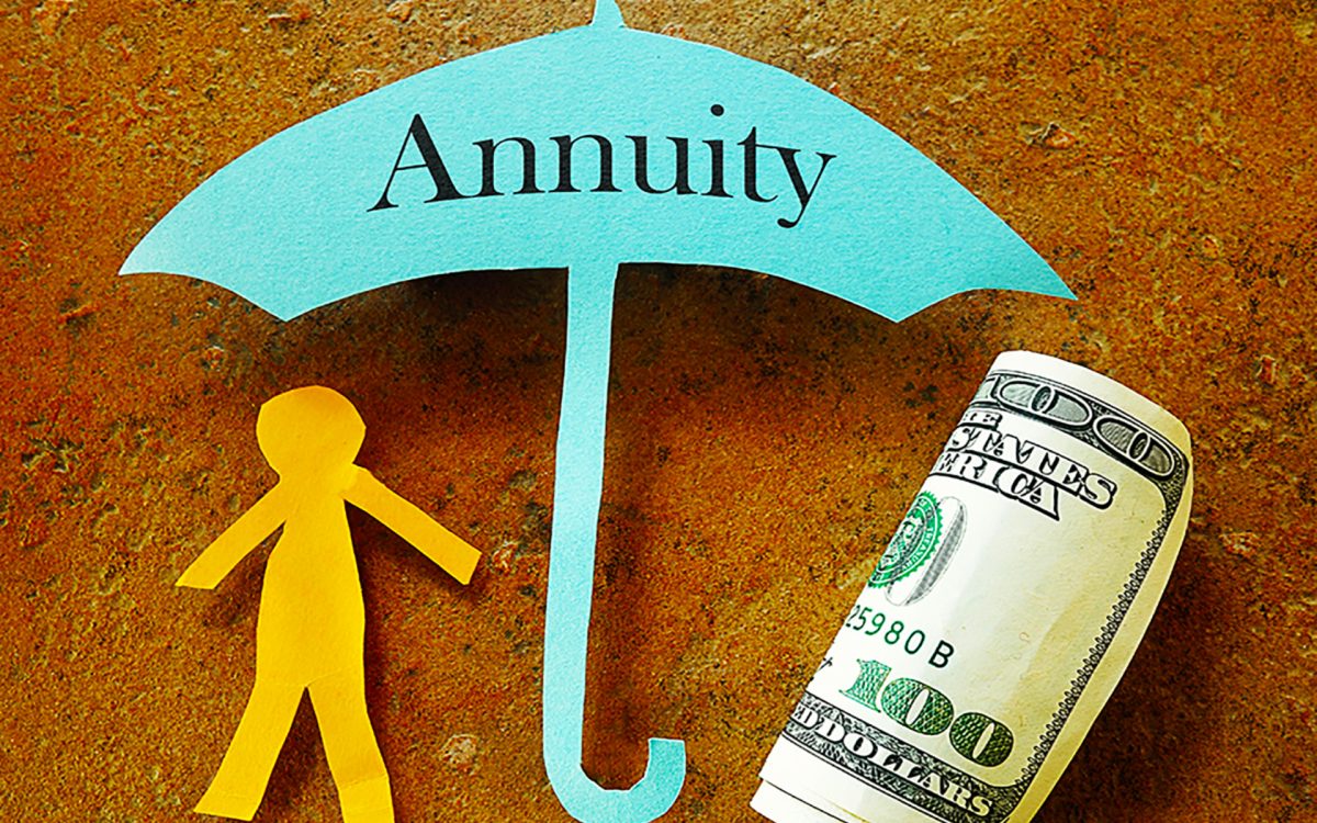 paper cut out stick figure and a rolled up hundred dollar bill sheltered under a paper cut umbrella labeled annuity